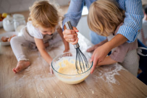 Woman cooking with two young children