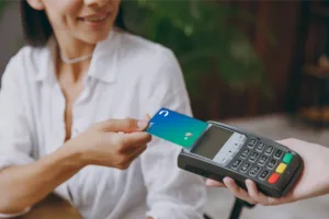 Woman tapping card reader with UCCU card