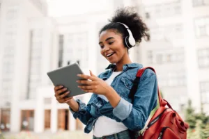 Young girl with tablet and headphones wearing a backpack