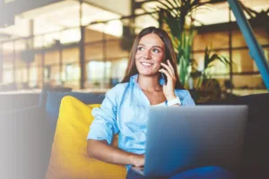 Smiling woman sitting on couch with laptop