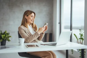 Smiling woman at desk with laptop and tablet