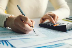 Woman using calculator to fill out taxes