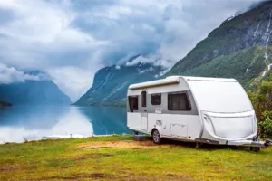 Camping trailer by lake and mountains