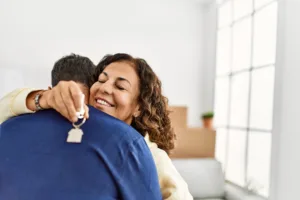 Woman hugging man while holding home keys