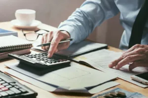 Man using calculator with paper documents