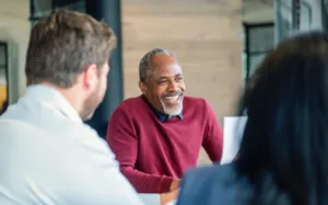 Man in red sweater smiling about his mortgage loan servicing